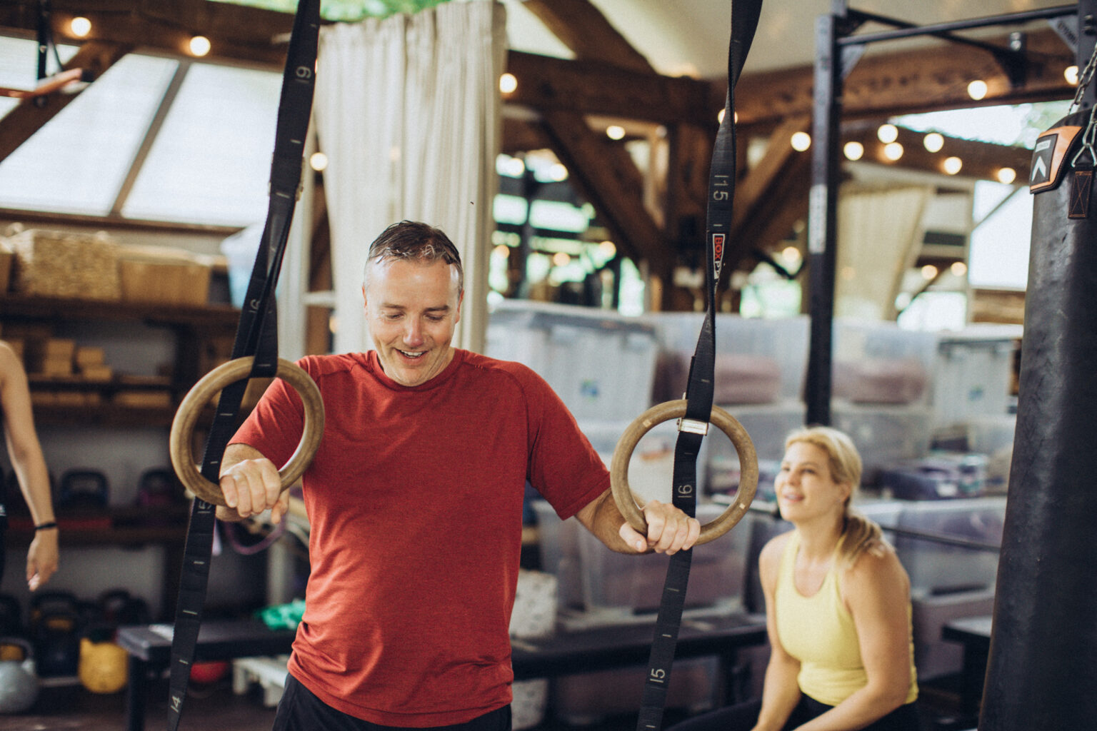 A coach demonstrating on gymnastic rings