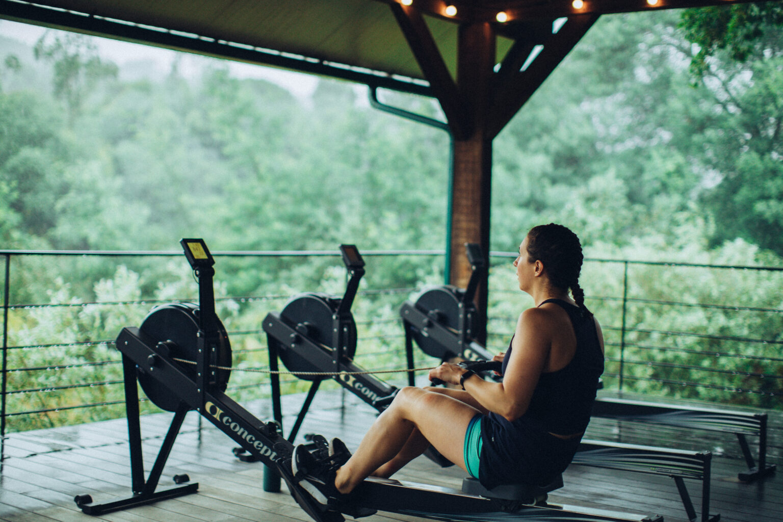 A guest on a rowing machine overlooking the forest