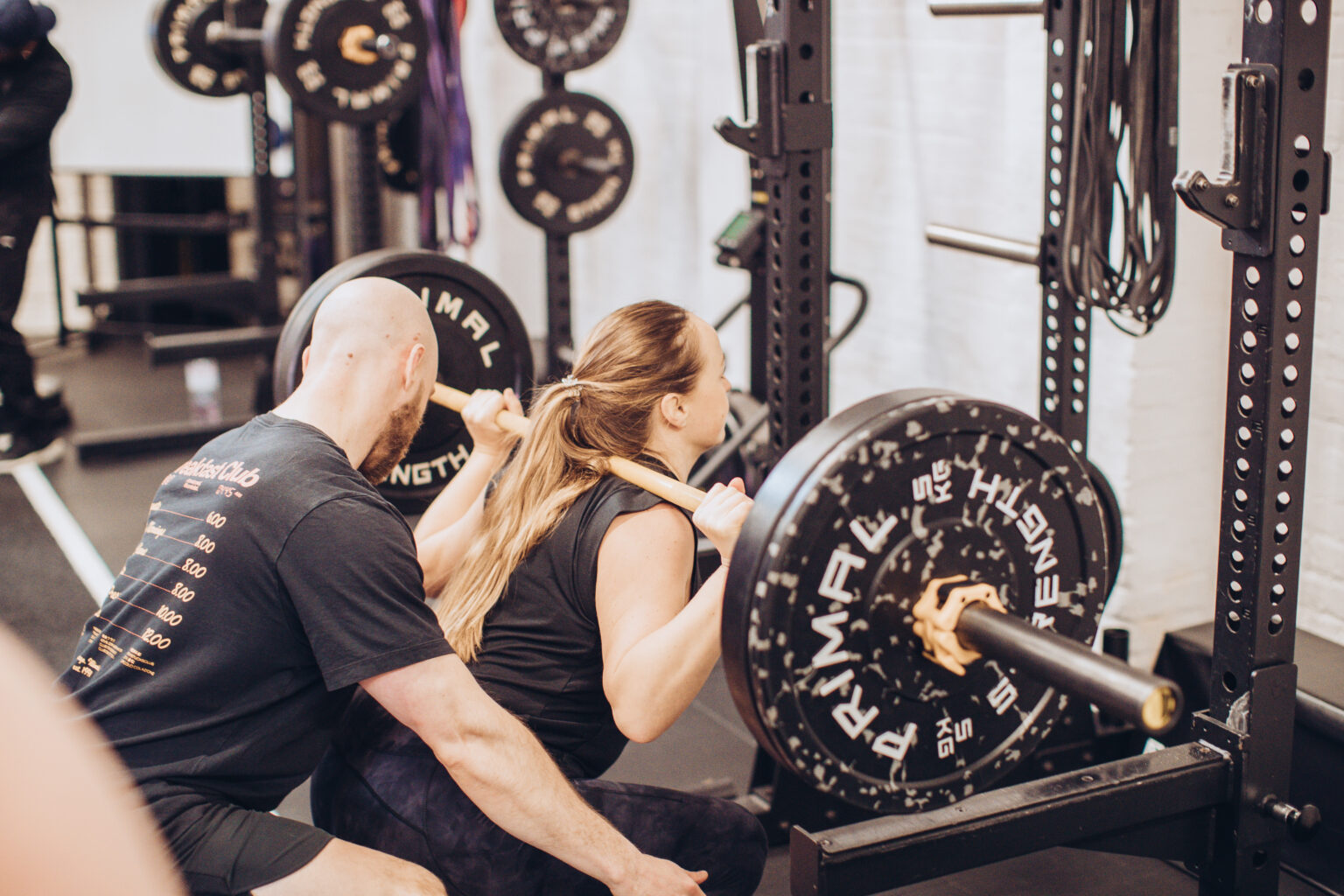 Nick Collins coaching a client through a barbell squat