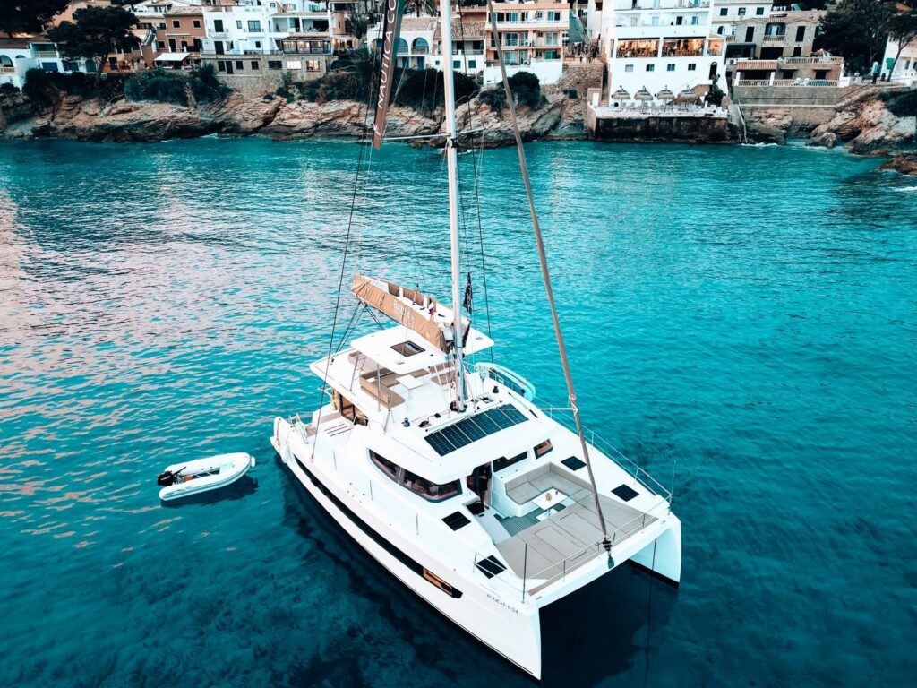 A catamaran anchored in a turquoise Mallorcan cove