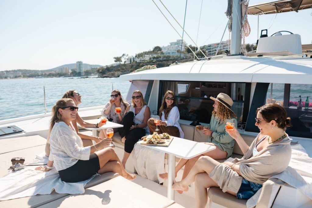 Guests sharing drinks on the deck of a catamaran