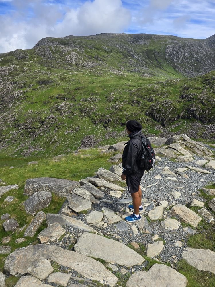 A hiker on a stone path in the Snowdon valley