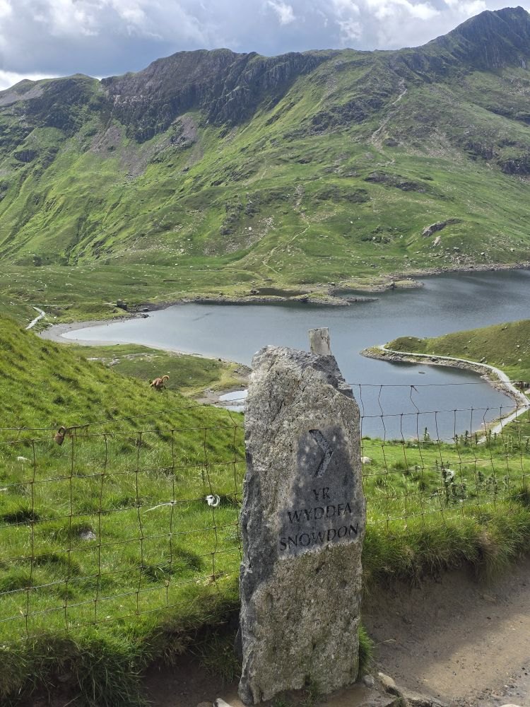 A standing stone above a lake on the climb up Snowdon